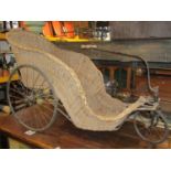 A 19th century wicker bath chair, sprung steel frame with wire spoke wheels, hard rubber tyres,