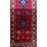 Good Hamadan runner with three blue medallions upon a red ground, 320 x 110cm