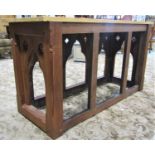 A pitched pine altar table with chamfered and pierced gothic tracery framework beneath a later