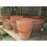 A small quantity of terracotta flower pots and planters of varying size and design, some with