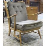 An Ercol light beechwood open armchair with down swept moulded arms and splay supports