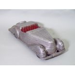 Unusual 1930's style model car in cast metal with silver finish and painted red seat. Length 33cm
