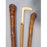 Two Japanese carved bamboo walking sticks, one decorated with a snake, the other a geisha, with a