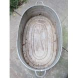 An oval two handled galvanised tin bath with screw cap and banded detail, 92 cm long (measurement