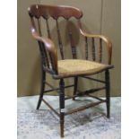A late Victorian/Edwardian oak, or possibly ashwood, spindleback armchair with cane panelled seat