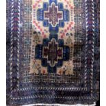 Antique Persian three medallion rug on a fawn ground with navy blue running fields, 210 x 120cm (af)