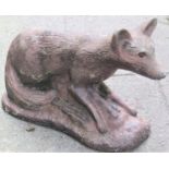 A reclaimed garden ornament in the form of a fox in pensive pose with combined naturalistic base and