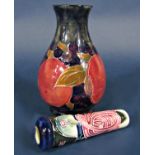 A Moorcroft vase with fruit decoration on a dark blue mottled ground with painted signature and