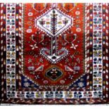 Unusual Ardabil rug with various medallions and still-lifes upon an orange ground, 205 x 130cm