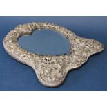 Edwardian silver shaped easel mirror, decorated and pierced in relief with various cherubs and