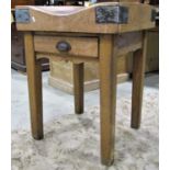 A well used beech framed butchers block, 61 cm square, raised on square cut supports, fitted with