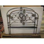 A 19th century 4ft 6 steel bedstead with arched tubular frame and decorative cast foliate detail