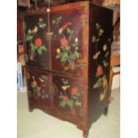 A Chinese lacquered cabinet on two tiers with painted detail and soapstone inset detail, birds,