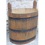 Substantial coopered oak bin of oval form with steel work bands, possibly log or grain storage