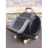 A Victorian tole ware coal scuttle with shaped lid ,cast fittings and ceramic castors