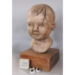 Unusual carved wooden bust sculpture of a babies bust upon an oak plinth, 28cm high, together with