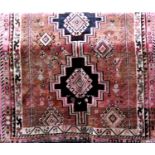 Good quality full pile Persian shiraz carpet with central block medallion upon a washed red