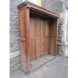 A well made ecclesiastical oak floorstanding open hanging cupboard with chamfered panelled framework