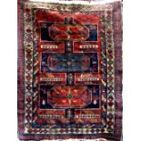 Afghan three medallion rug with brick red highlights upon an electric blue ground, 125 x 95 cm (af)