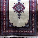 A Persian Tabriz rug with central floral blue and red medallion with thick running borders upon an