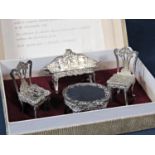 Cased collection of miniature furniture comprising two Chippendale type chairs, a bench and a table,