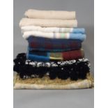 Collection of vintage blankets and bed covers including a black and white fringed bed cover by