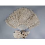 Vintage brise lace fan with painted wooden guards and sticks, each stick supporting a wide lace