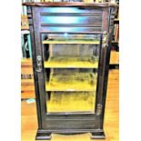 An Edwardian mahogany music cabinet enclosed by a rectangular bevelled edge glazed panelled door