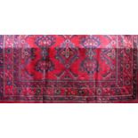 Large Turkish wool country house carpet with various navy blue medallions upon a red ground, 440 x
