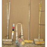 A collection of croquet pieces, comprising four mallets (one stamped Harrods), centre spike, five