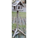 A rustic wooden freestanding bird table with pitched roof, 162cm high