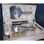 Cased 1920s silver six piece dressing set comprising four brushes, hand mirror and silver topped