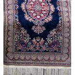 Good quality Tabriz rug with typical central red and blue floral medallion upon a navy blue