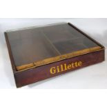 Vintage razor display cabinet inscribed Gillette, with hinged glass top, 33cm wide