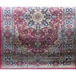 A Belgian wool Kashan type rug with central blue floral medallion upon a red ground, 195 x 130 cm