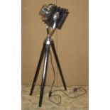 A vintage style lantern in the form of a bellows camera on a tripod base with black and chrome