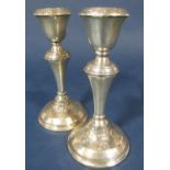 Pair of early 20th century silver candlesticks with embossed acanthus decoration upon stepped