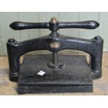 A small but heavy vintage cast iron book press, the central screw thread with T shaped club