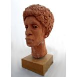 Terracotta bust sculpture of an Afrocentric character upon a teakwood plinth base, 50cm high