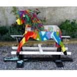 Vintage rocking horse with abstract painted decoration and rag doll mane from the set of the