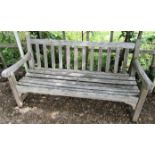 A weathered teak wood garden bench to commemorate the 1977 Silver Jubilee, 153cm wide