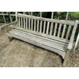 A weathered teak wood garden bench, to commemorate the 1977 Silver Jubilee, 180cm wide