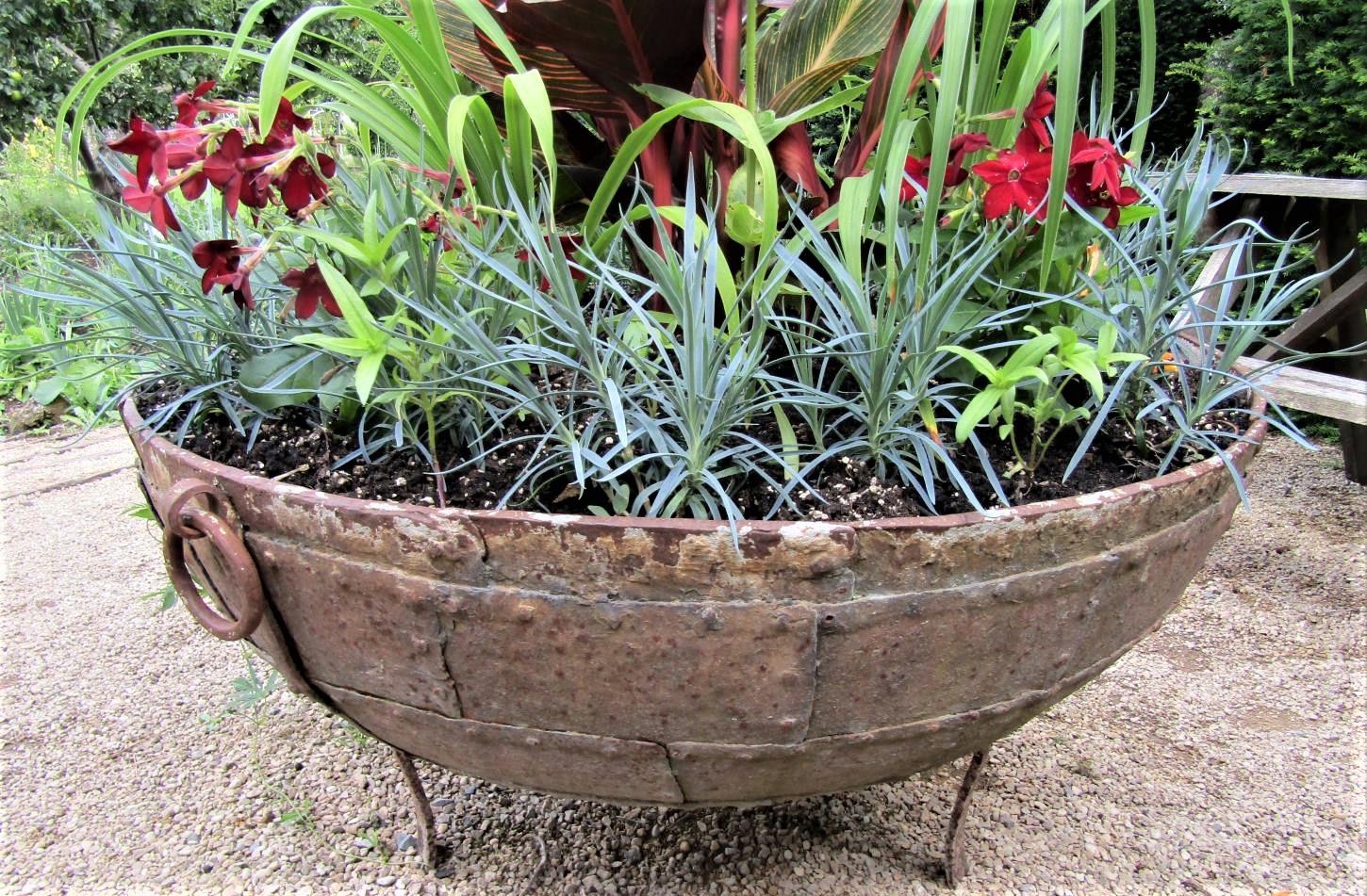 A riveted iron cauldron with ring handles, raised on a later base with scrolled supports, 110cm - Image 2 of 3