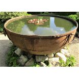 A massive riveted iron cauldron with ring handles (water tight) 170cm diameter
