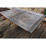 A good quality weathered teak garden table with slatted top and folding x shaped frame, 155cm x 95cm