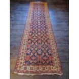 An old eastern carpet, the central field in ink blue with multi repeating abstract floral detail,