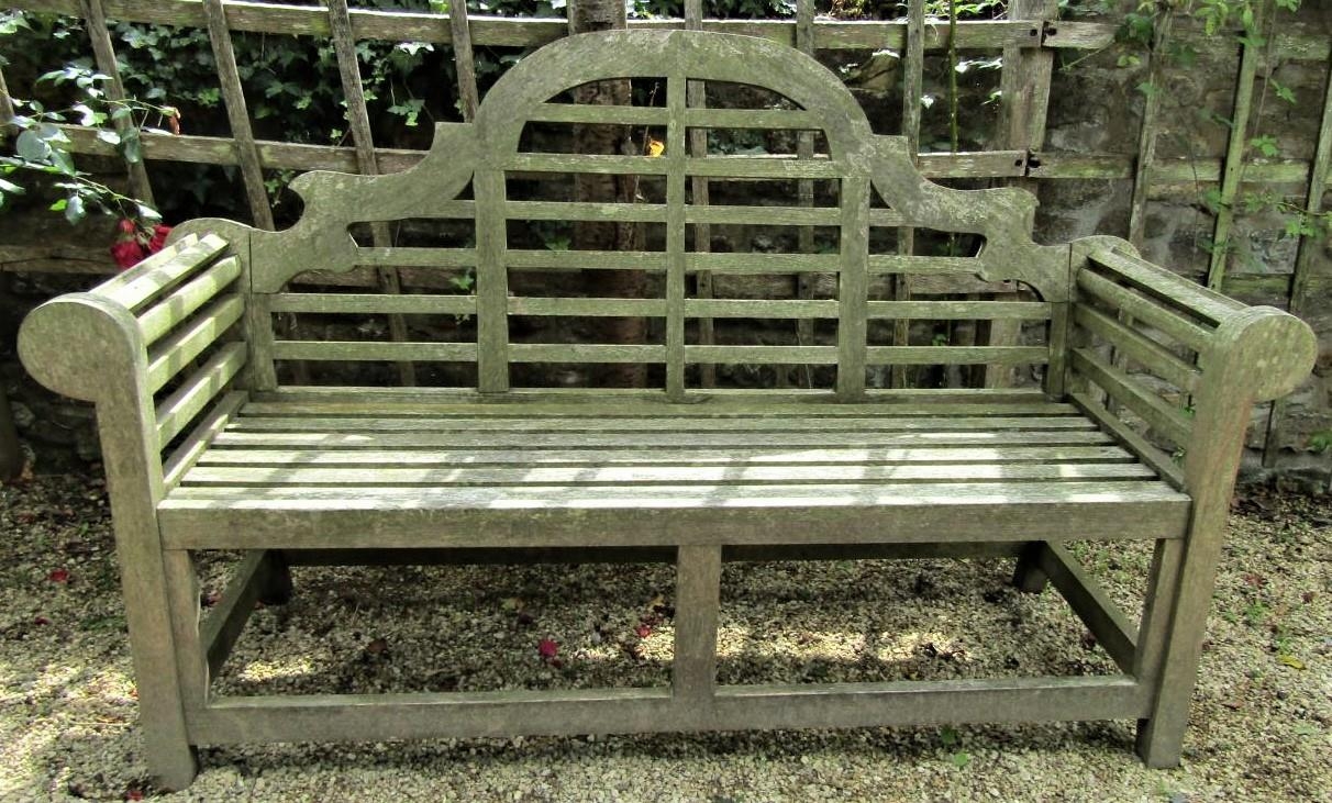 A weathered teak wood garden seat in the Lutyens manner, 165cm wide