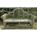 A weathered teak wood garden seat in the Lutyens manner, 165cm wide