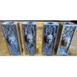 A set of four polished oak carvings, each with an individual mask and trail floral detail, 17cm high