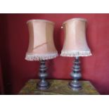 A pair of turned timber table lamps, with simulated pewter lustre finish, 53cm high to bulb holder